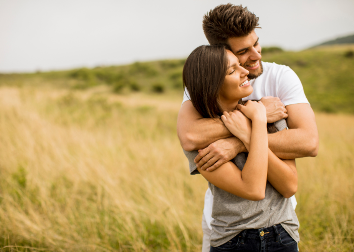 an image of a couple hugging each other of a hill